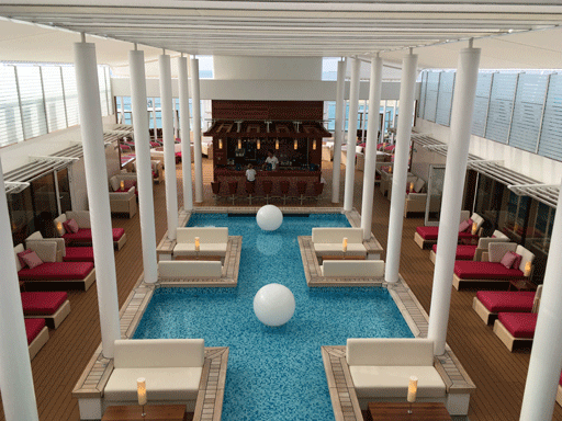 Blick auf das Patio Deck mit Wasserfläche, Bar und Liegen. AIDAperla buchen - Erholen auf dem Patio Deck