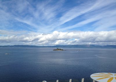 Meer, Insel vor Festland und Wolken